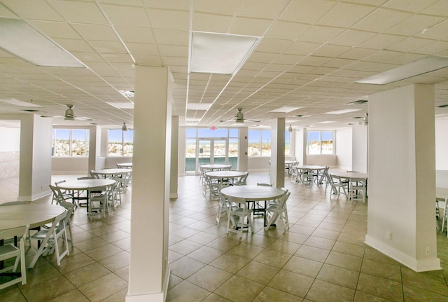 dining space featuring a ceiling fan, baseboards, and tile patterned flooring