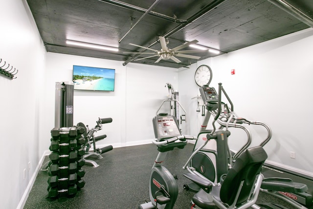 exercise area with ceiling fan and baseboards