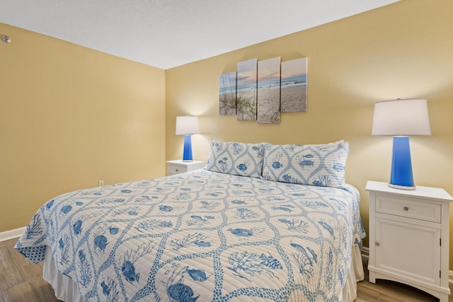 bedroom with wood finished floors and baseboards
