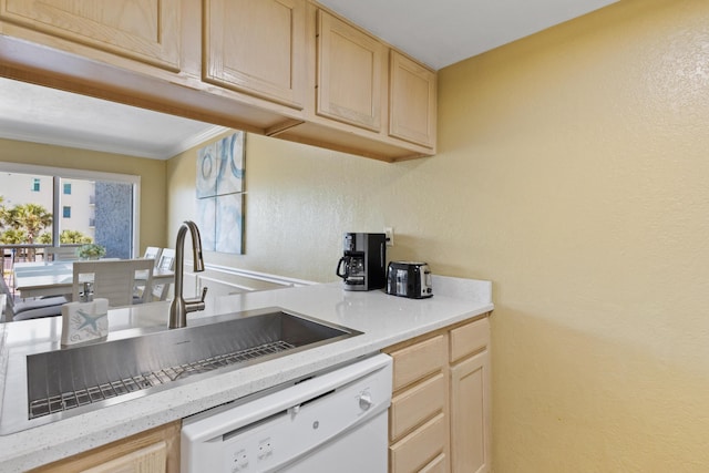 kitchen featuring white dishwasher, light brown cabinetry, a sink, light countertops, and a textured wall