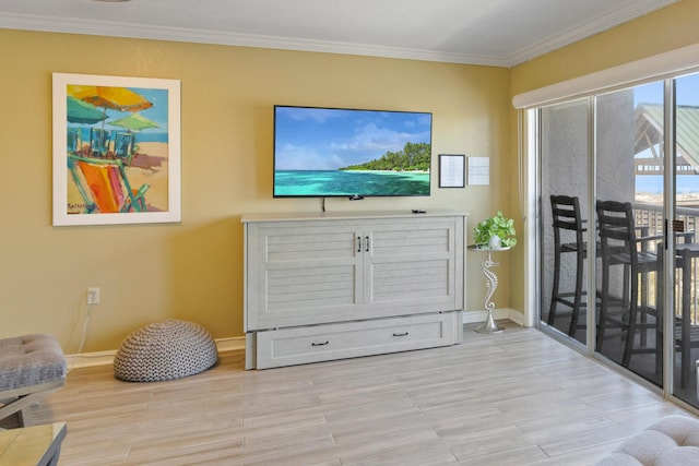living room featuring ornamental molding, baseboards, and wood finished floors
