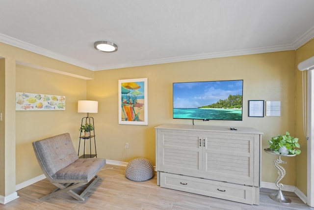 sitting room with ornamental molding, wood finished floors, and baseboards