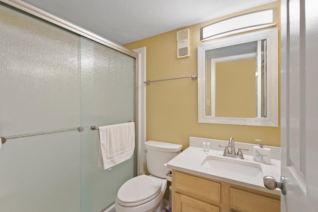 bathroom featuring vanity, a textured ceiling, toilet, and an enclosed shower