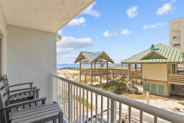 balcony featuring view of water and beach