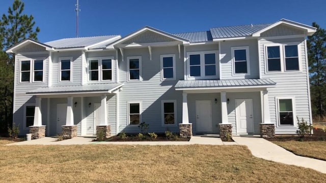 view of property with metal roof, a standing seam roof, and a front yard