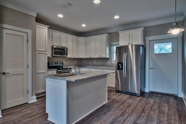 kitchen with dark wood-type flooring, white cabinetry, stainless steel appliances, pendant lighting, and a center island with sink