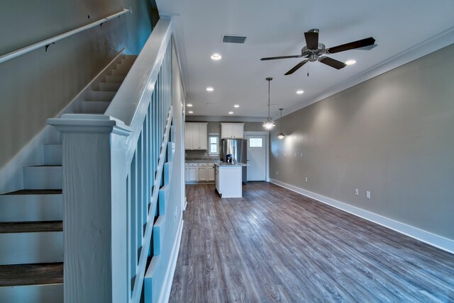 interior space featuring ceiling fan, crown molding, and wood-type flooring