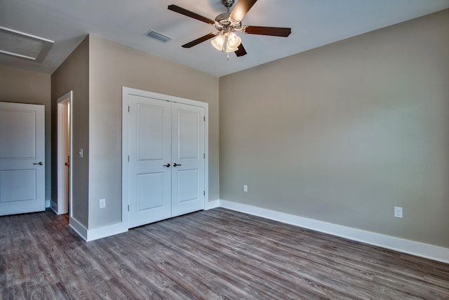 unfurnished bedroom with ceiling fan, dark hardwood / wood-style floors, and a closet