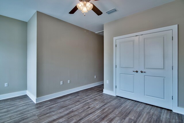 unfurnished bedroom featuring a closet, ceiling fan, and dark hardwood / wood-style floors