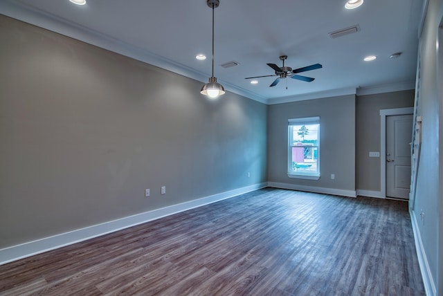 spare room with ceiling fan, crown molding, and dark wood-type flooring