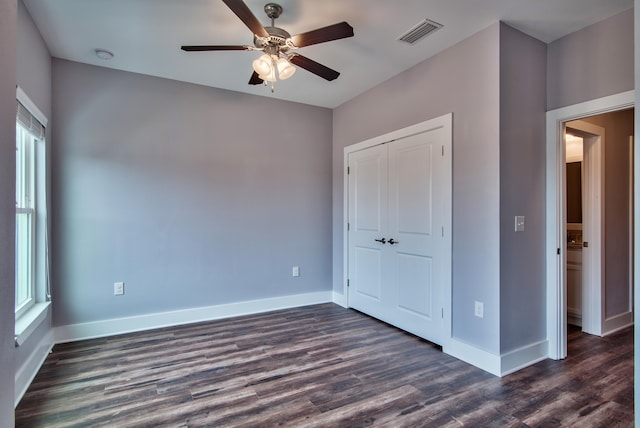 unfurnished bedroom with a closet, ceiling fan, and dark hardwood / wood-style floors