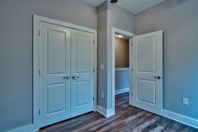 unfurnished bedroom with dark wood-type flooring and a closet