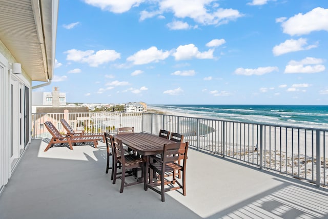 view of patio with a balcony, a beach view, and a water view