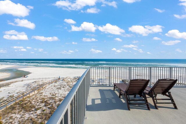 balcony featuring a water view and a view of the beach