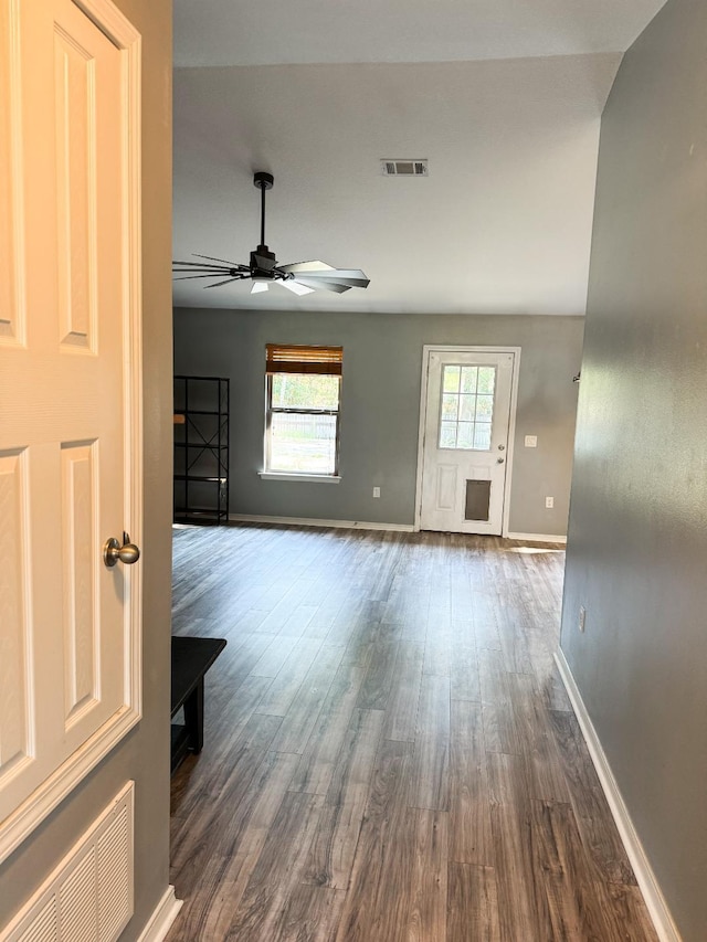 unfurnished living room with visible vents, baseboards, and dark wood-type flooring