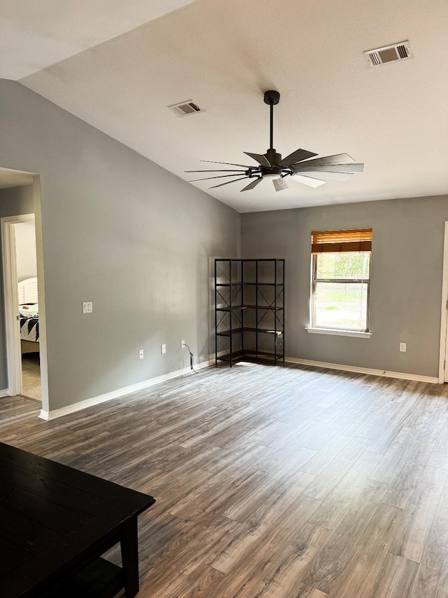 spare room with ceiling fan, lofted ceiling, and wood-type flooring