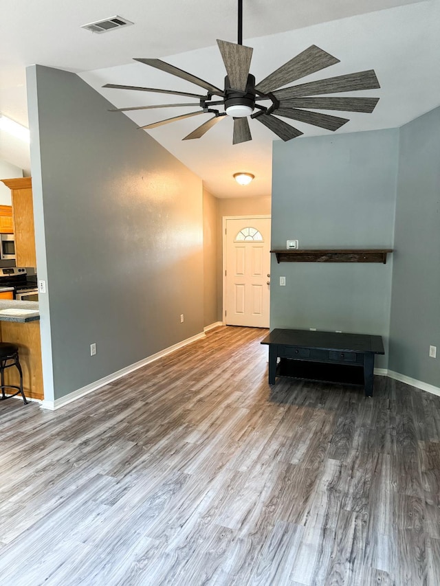 unfurnished living room featuring visible vents, a ceiling fan, wood finished floors, baseboards, and lofted ceiling