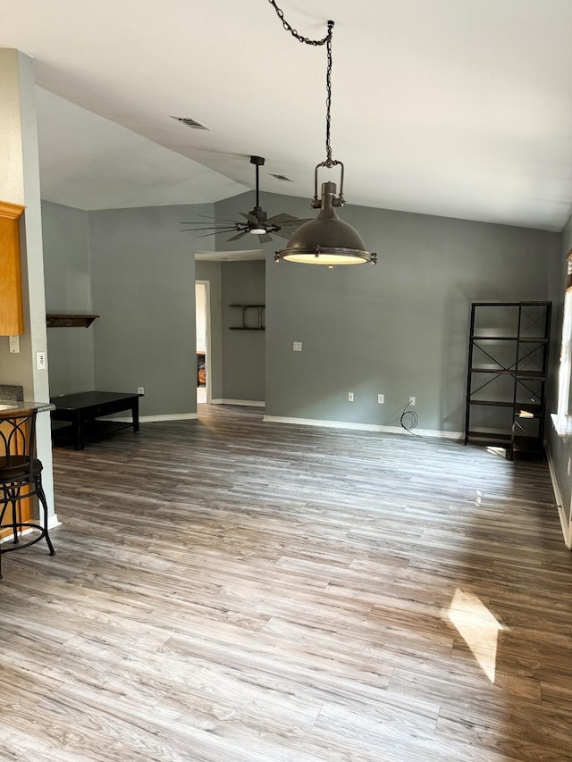 living room featuring ceiling fan, vaulted ceiling, and wood-type flooring