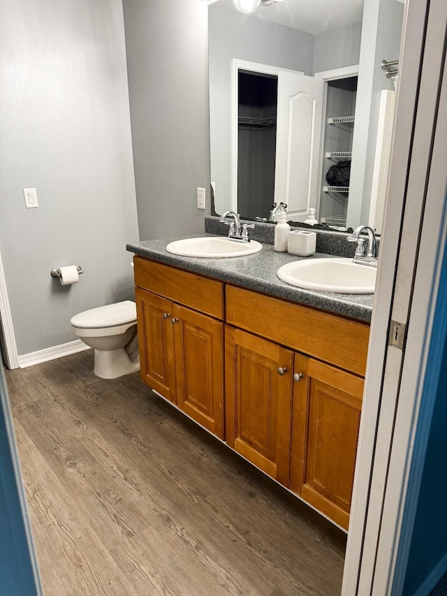 bathroom with toilet, hardwood / wood-style flooring, and vanity