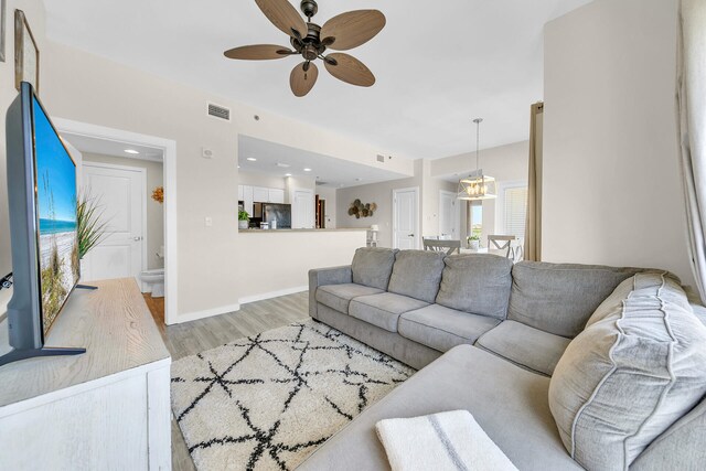 living room with light wood-type flooring and ceiling fan