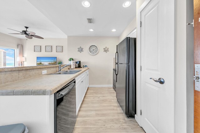 kitchen featuring white cabinets, light wood-type flooring, fridge, and dishwashing machine