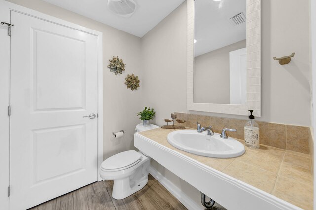 bathroom with sink, toilet, and wood-type flooring