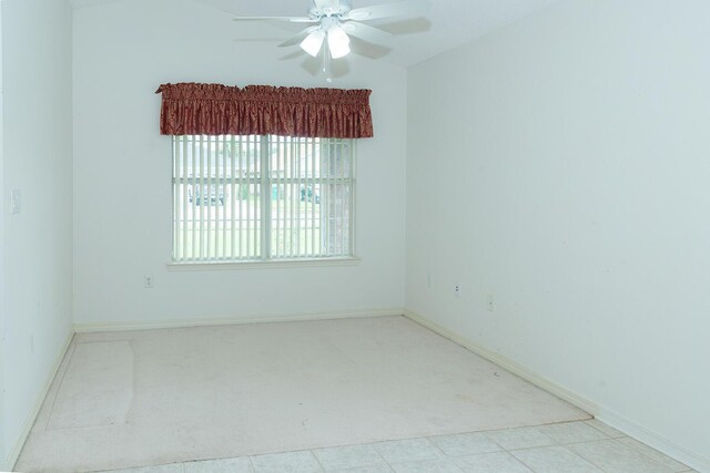 tiled empty room featuring ceiling fan