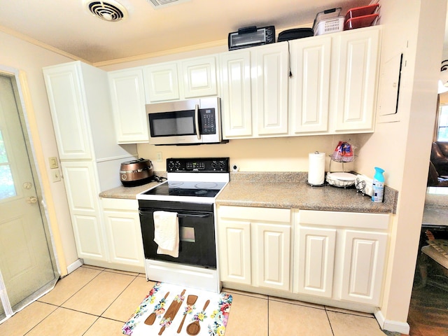 kitchen featuring white range with electric stovetop, light tile patterned floors, and white cabinets