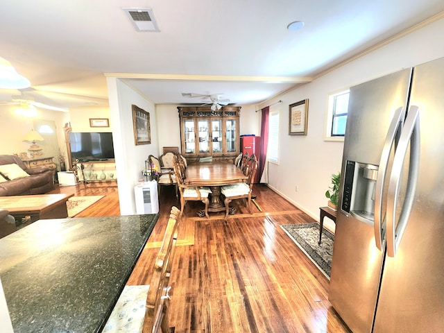 dining space with crown molding, ceiling fan, and wood-type flooring