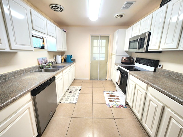 kitchen featuring light tile patterned floors, sink, stainless steel appliances, and white cabinets