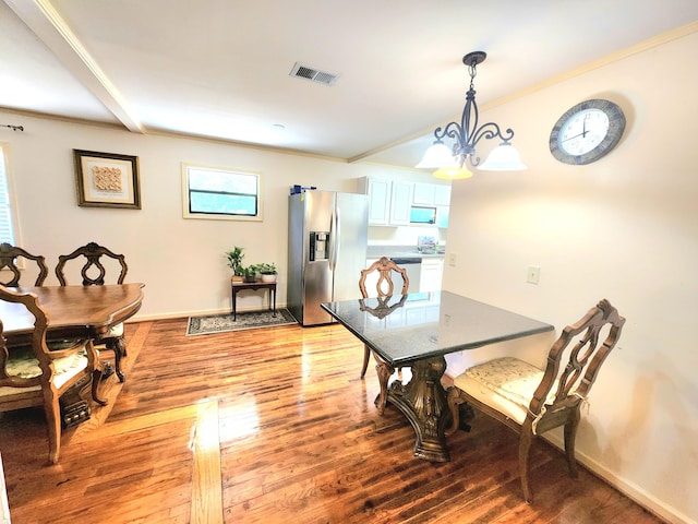 dining area featuring wood-type flooring and a chandelier