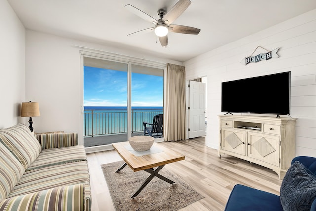 living room featuring ceiling fan and light hardwood / wood-style flooring