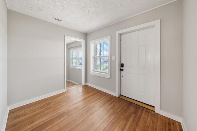 entrance foyer with hardwood / wood-style flooring and a textured ceiling