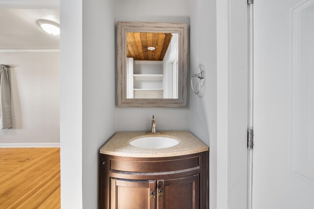 bathroom featuring hardwood / wood-style flooring, wooden ceiling, and vanity