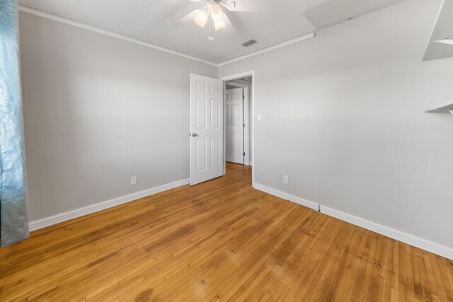 spare room with light wood-type flooring, ornamental molding, and ceiling fan