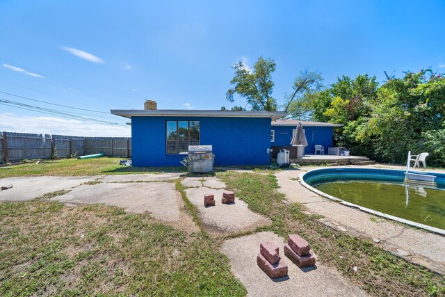 back of house featuring a fenced in pool and a patio area