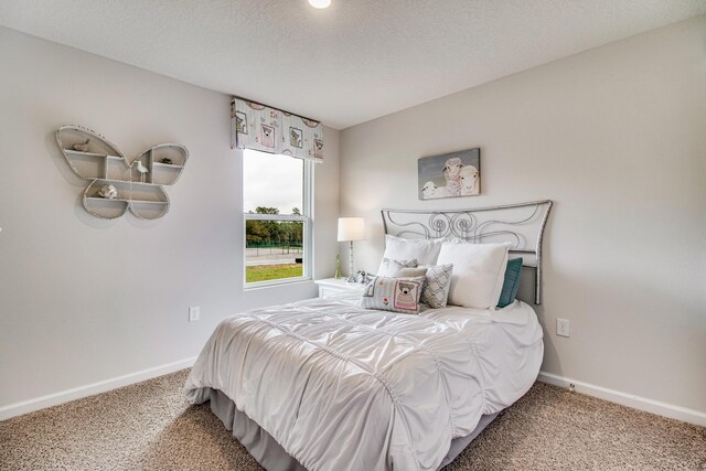 bedroom with a textured ceiling and carpet flooring