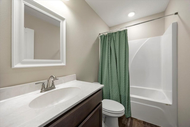 full bathroom with a textured ceiling, hardwood / wood-style flooring, shower / tub combo with curtain, vanity, and toilet