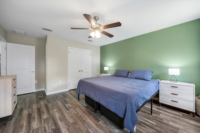 bedroom featuring ceiling fan, a closet, and dark wood-type flooring