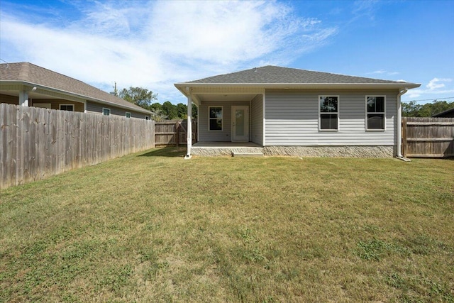 rear view of property featuring a yard