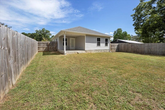 back of house with a lawn and a patio area