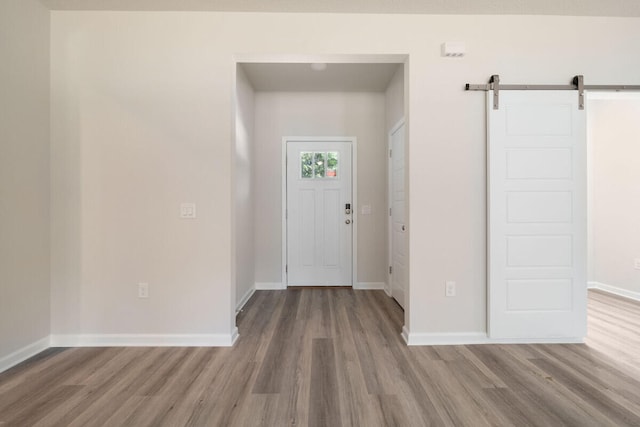 foyer entrance with hardwood / wood-style floors and a barn door