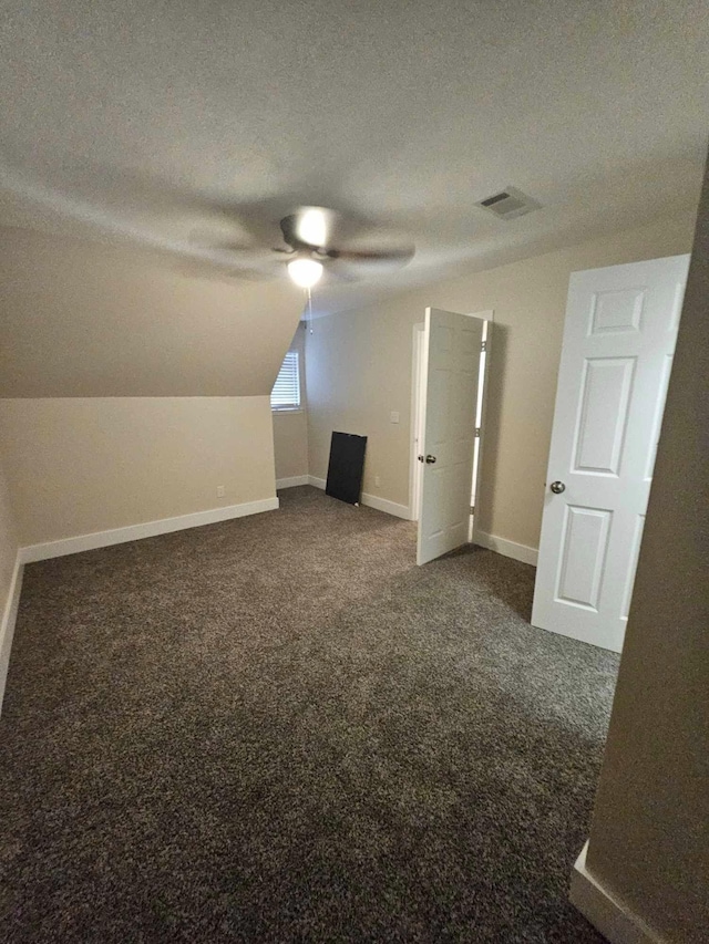 bonus room featuring ceiling fan, vaulted ceiling, a textured ceiling, and carpet floors