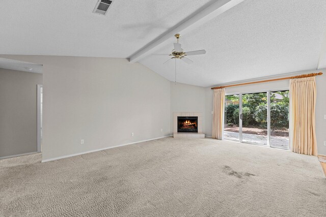 unfurnished living room with carpet flooring, ceiling fan, a tile fireplace, and lofted ceiling with beams