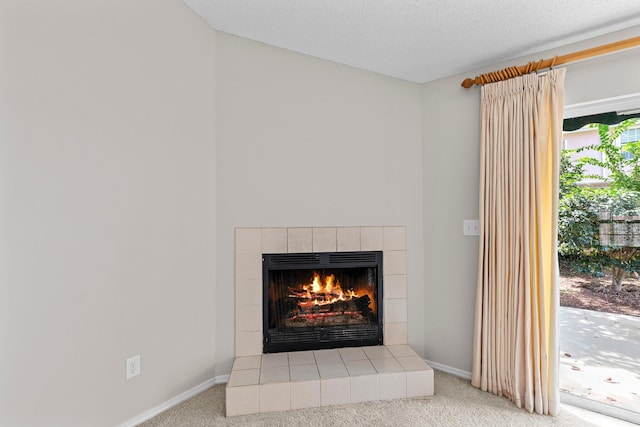 room details with a textured ceiling, a tiled fireplace, and carpet floors