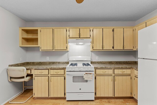 kitchen with a textured ceiling, light hardwood / wood-style flooring, white appliances, and tasteful backsplash