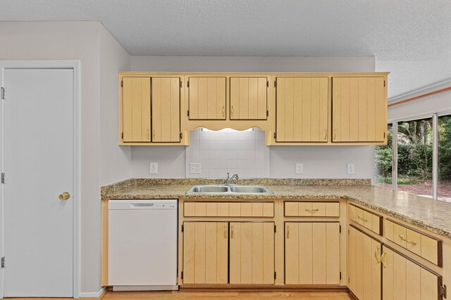 kitchen with a textured ceiling, white dishwasher, backsplash, sink, and light brown cabinets