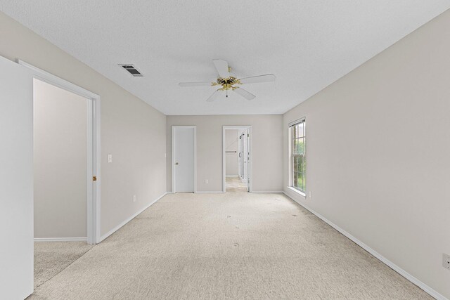 carpeted spare room with a textured ceiling and ceiling fan