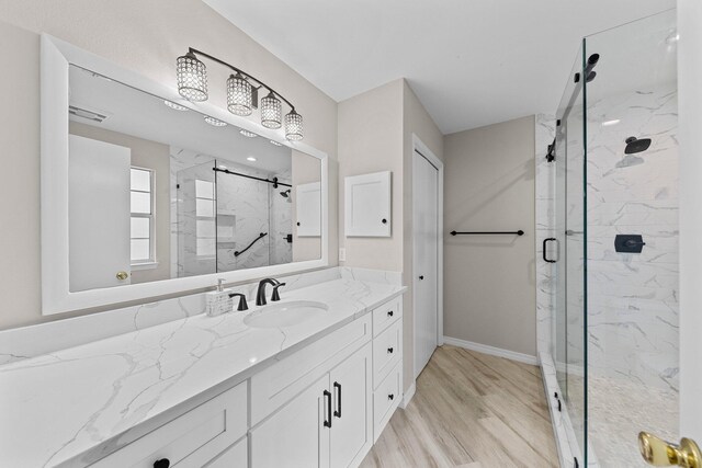 bathroom with walk in shower, wood-type flooring, and vanity