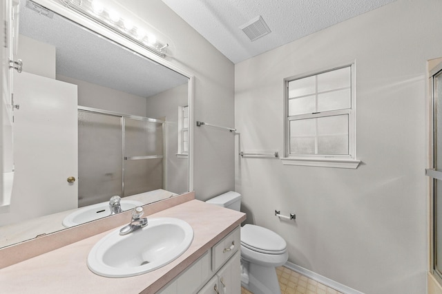 bathroom with a textured ceiling, vanity, toilet, and an enclosed shower